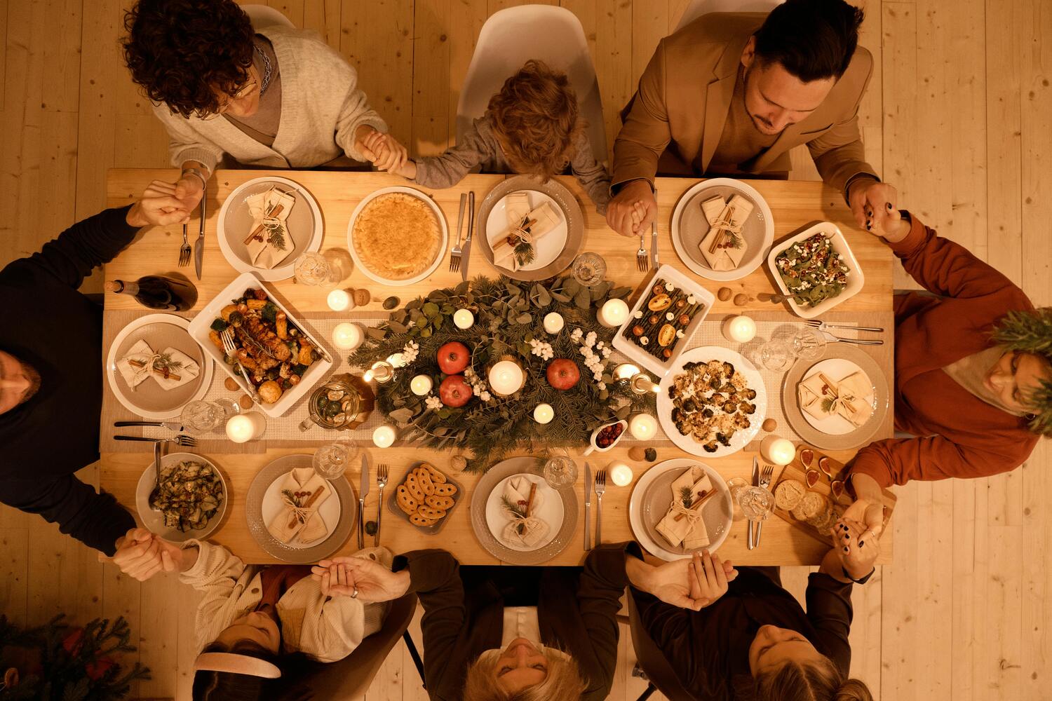 fa,mily holding hands around table