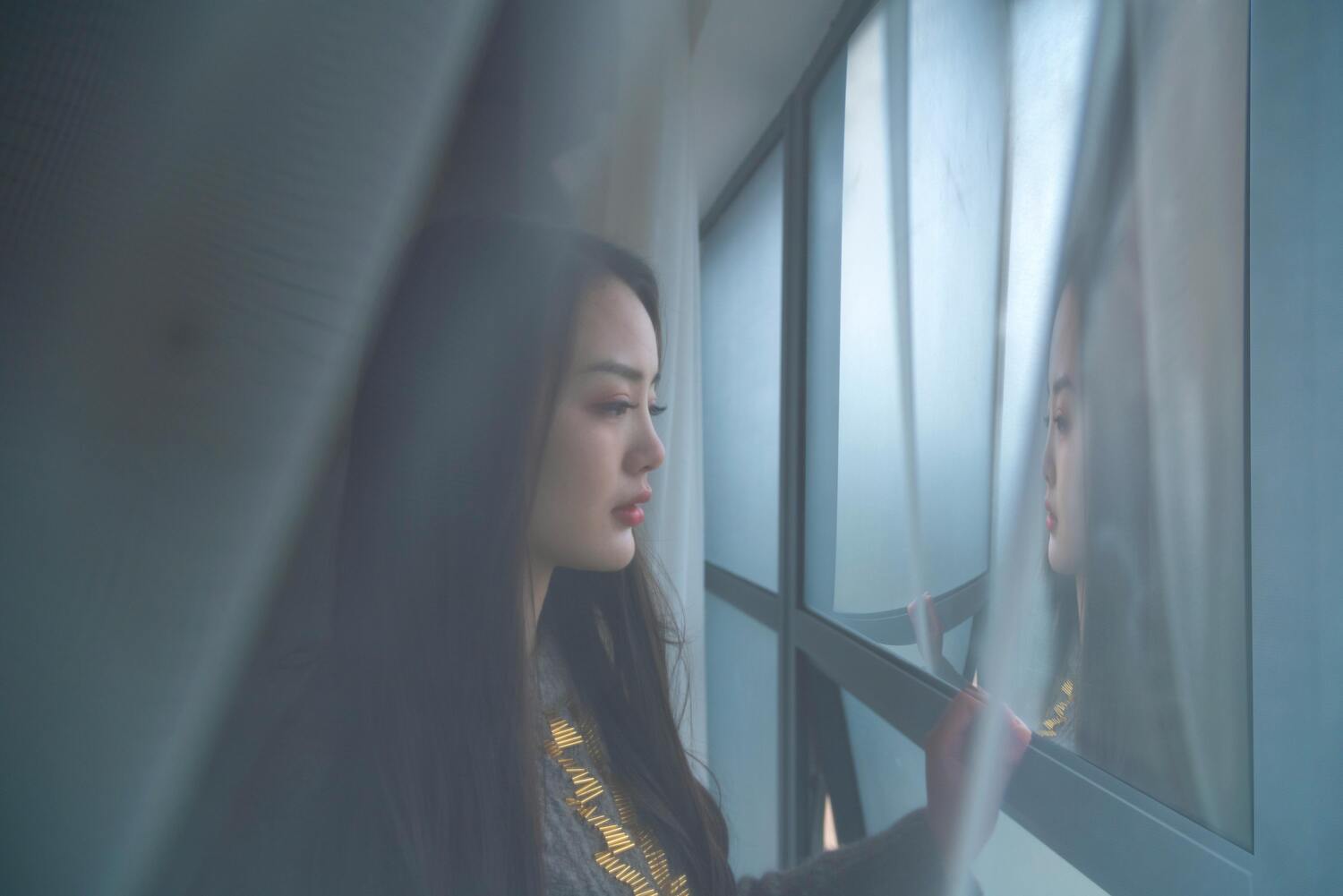 asian woman looking out of window